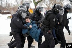 Polisi menahan seorang pria yang ingin memberi penghormatan untuk Alexey Navalny di St. Petersburg, Rusia, 17 Februari 2024. (Foto: AP Photo)