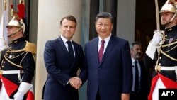 Presiden Prancis Emmanuel Macron (kiri) menyambut Presiden China Xi Jinping di Istana Elysee di Paris, Senin, 6 Mei 2024. (Foto: Ludovic Marin/ AFP)