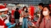 People check their temperature as they visit the Christmas light festival in Bangkok, Thailand, Dec. 21, 2020. 
