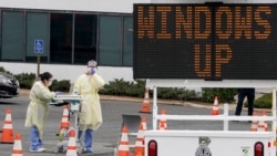 Trabajadores de salud en Arlington, Virginia, esperan conductores en un punto móvil de pruebas de detección del coronavirus, el 19 de marzo de 2020.